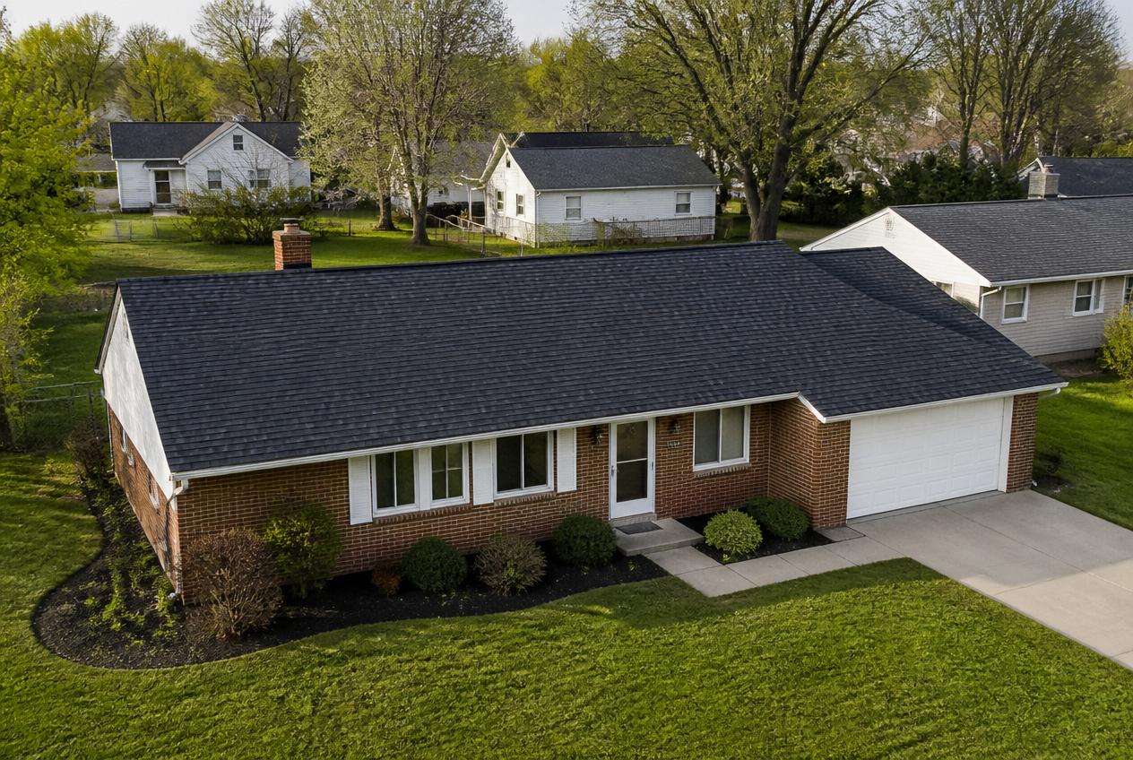 Completed roof replacement with charcoal architectural shingles on a ranch home