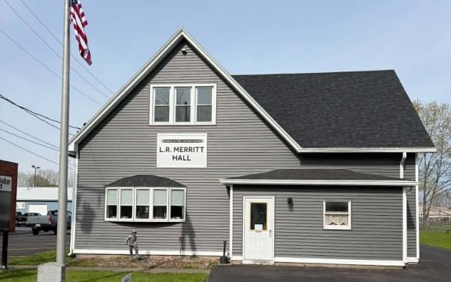 Gray-sided building with white trim and a new charcoal shingle roof